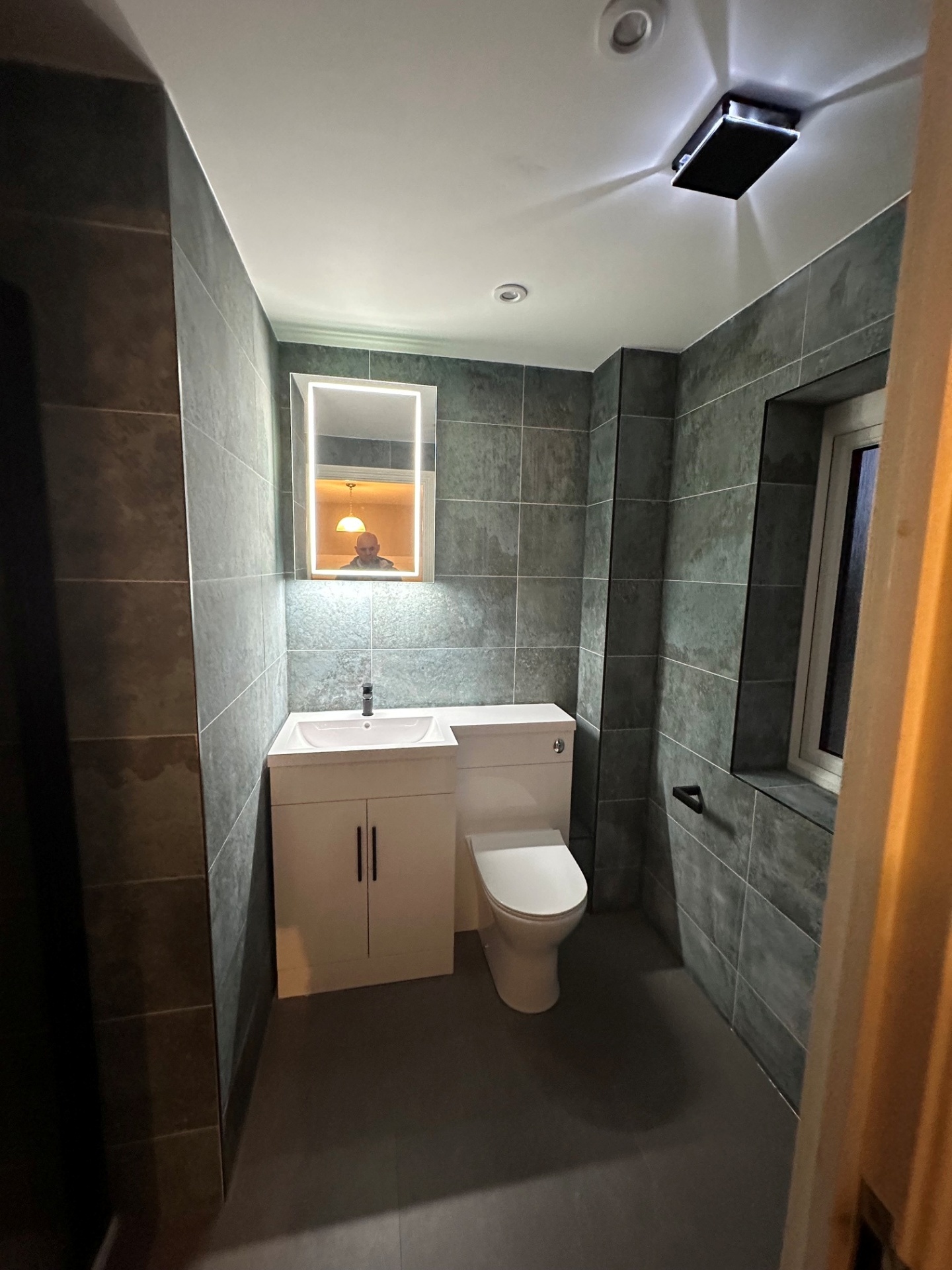 Slate-tiled cloakroom with LED mirror