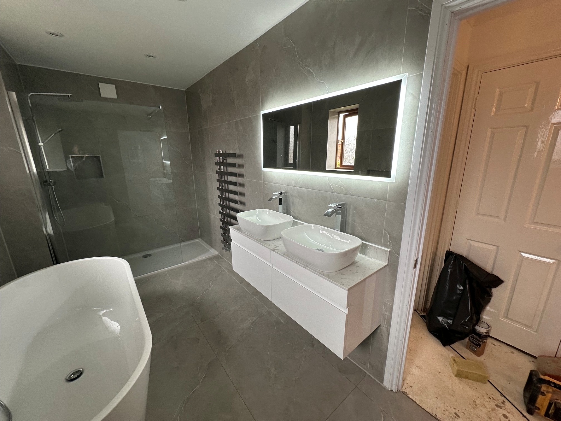 Marble-tiled ensuite with freestanding bath & twin vessel basins